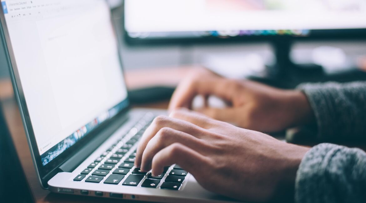 Hands writing on a laptop